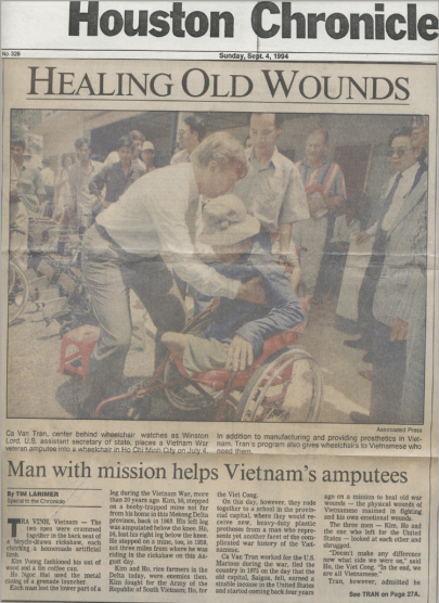 Ca Van Tran, center behind wheelchair watches as Winston Lord, U.S. assistant secretary of state, places a Vietnam War veteran apputee into a wheelchair in Ho Chi Minh City on July 4.  In addition to manufacturing and providing prosthetics in Vietnam, Tran