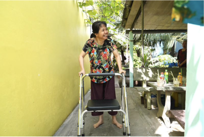 Figure 2: Ms Nga pushing a walker provided by the project after a few months of therapy