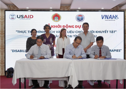 Figure 1: USAID / Vietnam Mission Director Alert Grubbs (standing, third from left), Chuong Tran, VNAH Board Members (far right) witnessed the project signing between representatives of VNAH (middle) and Bac Lieu government partners.