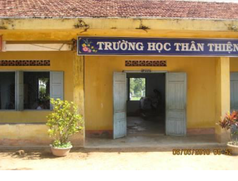 A yellow building with an open double door and windows labeled "TrÆ°á»ng Há»c ThÃ¢n Thiá»‡n" with a date stamp of 03/09/2010 08:51 AM at the bottom right corner.