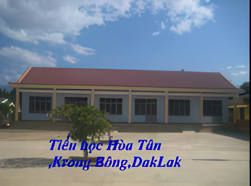 A single-story building with a red roof and several windows. Text at the bottom reads, "Tiá»ƒu há»c HÃ²a TÃ¢n, Krong BÃ´ng, DakLak.